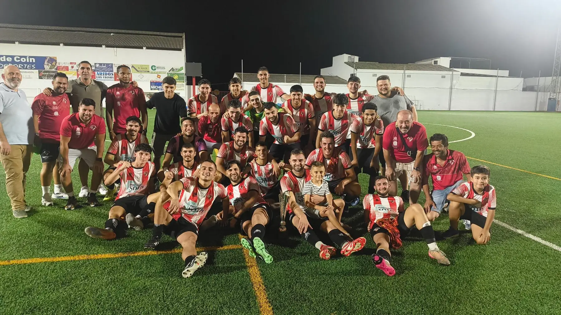 Los jugadores del Athletic de Coín posan sobre el césped tras ganar el Trofeo José Burgos